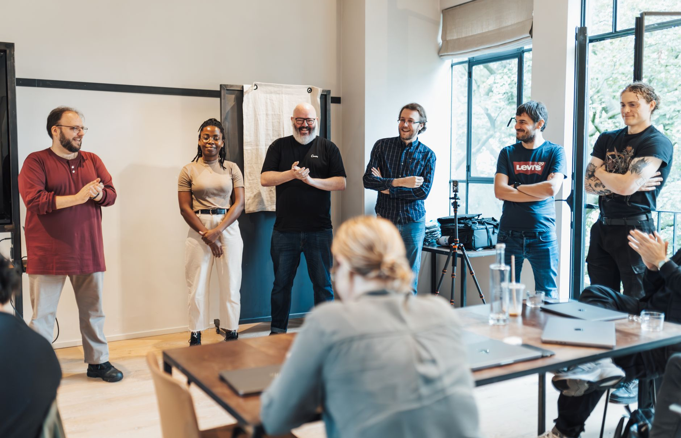An event crew briefing around a plan on a table in an empty hall before an event