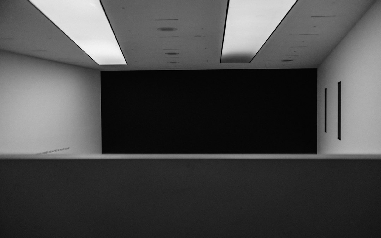 A backdrop wall with rail lighting and a dressed photo point in a hall before the doors open