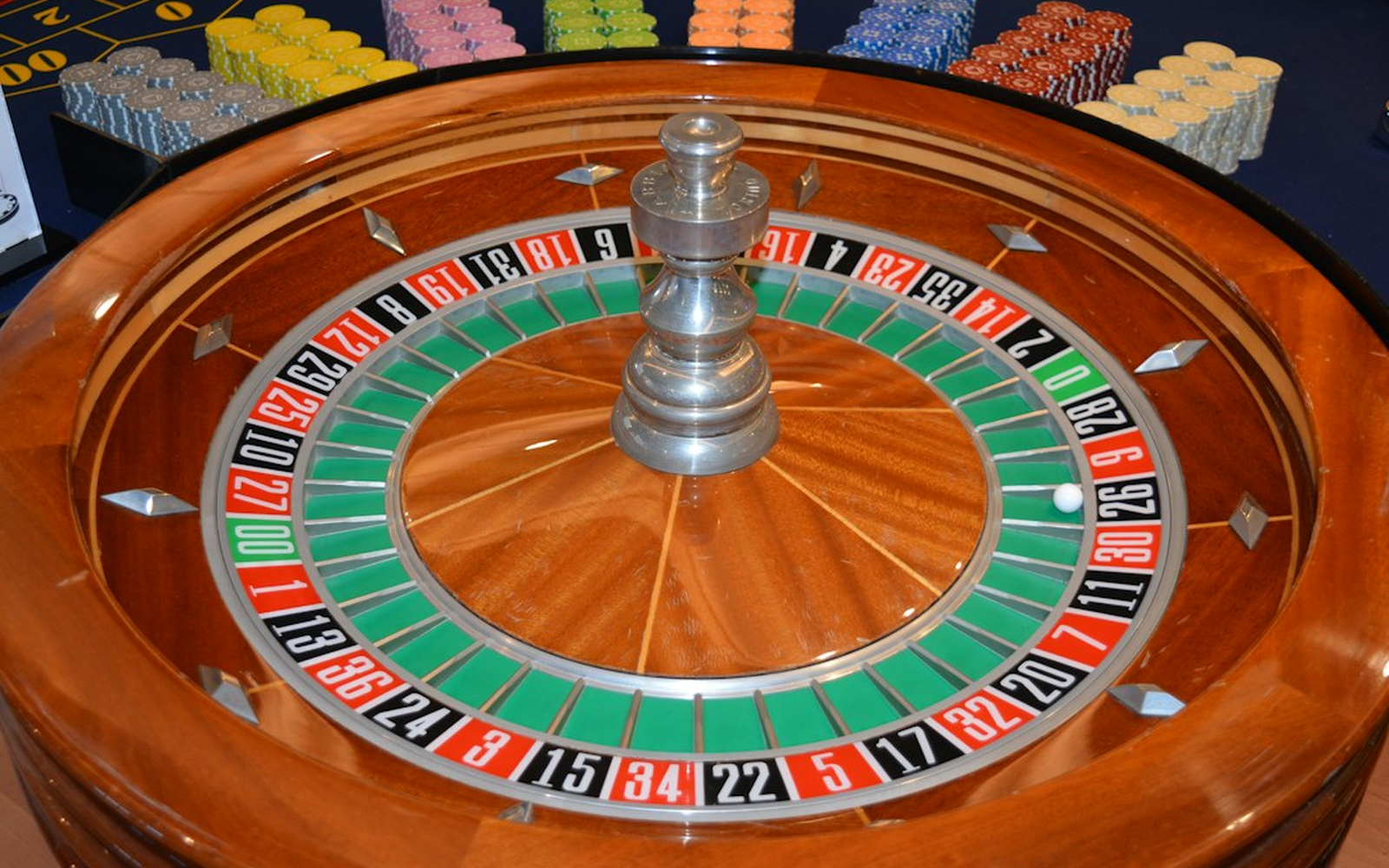 A themed roulette table with symbolic chips and a host in black tie explaining the rules to adult guests